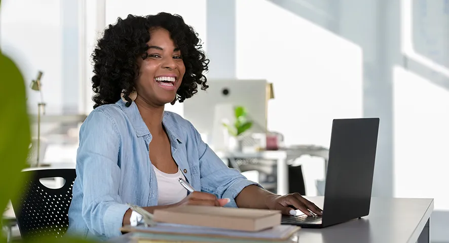 Black female smiling while working at her desk